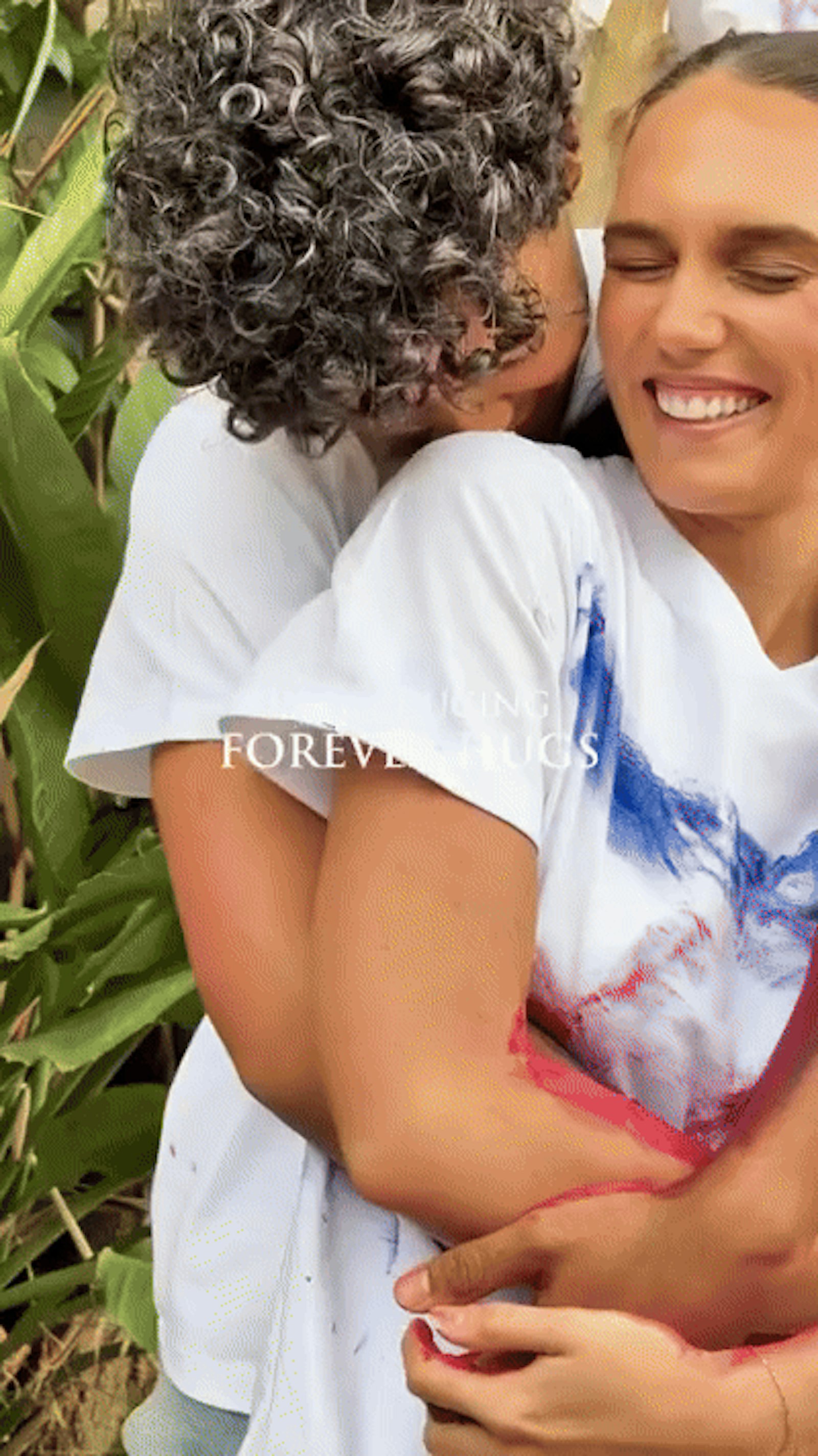 Two people hugging in paint-covered white shirts, a still from the Forever Hugs launch film